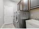 Laundry room with cabinets above a sink and washer and dryer; door to exterior at 3281 Saloman Ln, Clermont, FL 34711