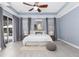 Bright main bedroom with light blue walls, fan, and view to the outside at 3281 Saloman Ln, Clermont, FL 34711