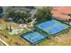 Aerial view showing community tennis and pickleball courts surrounded by lush landscaping at 3281 Saloman Ln, Clermont, FL 34711