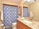 Bathroom vanity with granite countertop and white sink, as well as a toilet and shower with blue patterned curtain at 353 Wekiva Cove Rd, Longwood, FL 32779