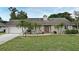 Charming single-story home features stone accents, a well-manicured lawn, and mature landscaping with palm trees at 353 Wekiva Cove Rd, Longwood, FL 32779