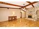 Inviting living room boasts wood floors, exposed beams, stone fireplace, and a ceiling fan for added comfort at 353 Wekiva Cove Rd, Longwood, FL 32779