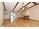 Bright living room with wood floors, exposed beams, ceiling fan, and sliding glass doors leading to the outdoors at 353 Wekiva Cove Rd, Longwood, FL 32779