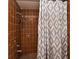 Shower stall tiled in brown tile with brown-and-white patterned shower curtain at 353 Wekiva Cove Rd, Longwood, FL 32779