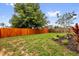 This backyard is spacious and features mature trees, lush grass, and a stained wood fence at 3622 Huntwicke Blvd, Davenport, FL 33837