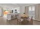 Bright dining area featuring a modern table set, luxury vinyl plank floors, and an adjacent kitchen at 3622 Huntwicke Blvd, Davenport, FL 33837