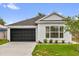 Charming single-story home with a well-manicured lawn, black garage door, and neutral paint at 3622 Huntwicke Blvd, Davenport, FL 33837