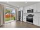 Well-lit kitchen featuring stainless steel appliances, a sliding glass door and white cabinets at 3622 Huntwicke Blvd, Davenport, FL 33837