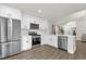 Bright kitchen with stainless steel appliances, white cabinets, and luxury vinyl plank flooring at 3622 Huntwicke Blvd, Davenport, FL 33837