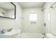 Updated bathroom featuring a tub, white tile, modern fixtures, and natural light at 3823 Avenue R Nw, Winter Haven, FL 33881