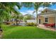 Beautiful backyard with large green lawn, pool, mature trees, and white pergola at 4065 Anissa Ave, Orlando, FL 32814