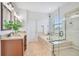 Elegant bathroom featuring double vanity, soaking tub, and glass-enclosed shower at 4065 Anissa Ave, Orlando, FL 32814