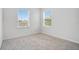 Empty bedroom with neutral carpeting and two bright windows at 4065 Anissa Ave, Orlando, FL 32814