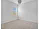 Empty bedroom with neutral carpeting, window, and simple light fixture at 4065 Anissa Ave, Orlando, FL 32814