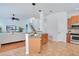 Kitchen with breakfast bar and stainless steel appliances open to the living room and staircase at 4065 Anissa Ave, Orlando, FL 32814