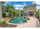 Backyard pool with tropical landscaping and stone patio of two-story home at 4065 Anissa Ave, Orlando, FL 32814