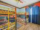 bedroom featuring colorful bunk beds, hardwood floors, and star-spangled decor at 407 Grand Reserve Dr, Davenport, FL 33837