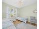 Comfortable bedroom with light green walls, hardwood floors, and plenty of natural light at 407 Grand Reserve Dr, Davenport, FL 33837