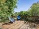 Wooden deck with two blue Adirondack chairs and small table surrounded by trees at 407 Grand Reserve Dr, Davenport, FL 33837