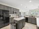 Well-lit kitchen features gray cabinets, stainless steel appliances, and an island with a white countertop at 407 Grand Reserve Dr, Davenport, FL 33837