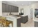 Stylish kitchen with modern gray cabinetry, granite countertops, and breakfast bar seating at 407 Grand Reserve Dr, Davenport, FL 33837