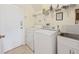 Bright laundry room with washer, dryer, utility sink, and shelving for storage at 407 Grand Reserve Dr, Davenport, FL 33837
