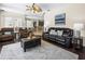 Spacious living room featuring wood floors, ceiling fan and leather sofas at 407 Grand Reserve Dr, Davenport, FL 33837
