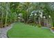 Picturesque backyard featuring artificial turf, gravel accents and flourishing tropical plants and landscaping at 418 Gleaming Andover Way, Longwood, FL 32779