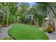 Serene backyard with artificial turf and meticulously maintained tropical landscaping at 418 Gleaming Andover Way, Longwood, FL 32779