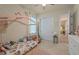 Bright bedroom featuring a pink canopy bed, plush toys, and a circular alphabet rug at 418 Gleaming Andover Way, Longwood, FL 32779