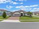 Beautiful single-story home with manicured lawn, brick driveway, and a three-car garage at 418 Gleaming Andover Way, Longwood, FL 32779