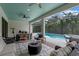 Entertain in style with the covered patio's outdoor dining and seating areas with a view of the pool at 418 Gleaming Andover Way, Longwood, FL 32779