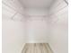 A white walk in closet features a wire shelf and clean white walls and new floors at 4333 Sw 157Th Ter, Ocala, FL 34481