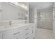 Bright bathroom featuring double sinks, a marble countertop, and a walk-in shower with glass doors at 4519 Willamette Cir, Orlando, FL 32826