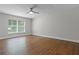 This bedroom features wood floors, a ceiling fan, and a large window allowing for ample natural light at 4519 Willamette Cir, Orlando, FL 32826