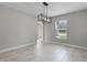 Open dining room features modern light fixture, window, and tiled floors at 4519 Willamette Cir, Orlando, FL 32826