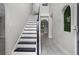 Bright foyer showcases the staircase with wooden banister and decorative greenery detail with tiled floors at 4519 Willamette Cir, Orlando, FL 32826