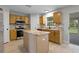 Bright kitchen features stainless steel appliances, center island, and convenient access to the outdoor screened patio at 4519 Willamette Cir, Orlando, FL 32826