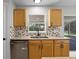 Galley kitchen features stainless steel appliances, tiled backsplash, and cabinets at 4519 Willamette Cir, Orlando, FL 32826