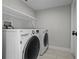 Convenient laundry room with modern washer and dryer, plus storage shelf at 4519 Willamette Cir, Orlando, FL 32826