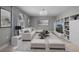 Bright and modern living room features neutral furniture, a stylish chandelier, and a custom built-in bookcase at 4519 Willamette Cir, Orlando, FL 32826