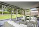 Screened-in porch with comfortable wicker furniture and views of the lush green backyard at 4519 Willamette Cir, Orlando, FL 32826