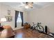 Well lit bedroom with a window, wood laminate flooring, a ceiling fan, and a bicycle for working out at 5063 Carillon Ln, Windermere, FL 34786