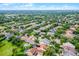 Expansive aerial view showcasing community homes and mature landscaping in a residential area near a picturesque lake at 5063 Carillon Ln, Windermere, FL 34786