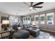 Open-concept living room with sectional sofa, fan, and view to the dining room and windows at 5063 Carillon Ln, Windermere, FL 34786
