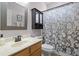Well-lit bathroom with a shower and tub combination featuring a decorative shower curtain and wood vanity at 5063 Carillon Ln, Windermere, FL 34786