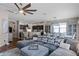 Open-concept living room with sectional sofa, fan, and view to the dining room and kitchen at 5063 Carillon Ln, Windermere, FL 34786
