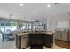 Open kitchen with granite countertops, dark cabinetry, stainless steel dishwasher, and views of the dining and living areas at 5063 Carillon Ln, Windermere, FL 34786