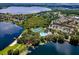An aerial view displays the neighborhood by a lake, showcasing community amenities like a tennis court and pool at 5063 Carillon Ln, Windermere, FL 34786