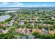 Scenic aerial view features well-placed homes amid verdant trees, with a glimpse of a serene lake in the distance at 5063 Carillon Ln, Windermere, FL 34786